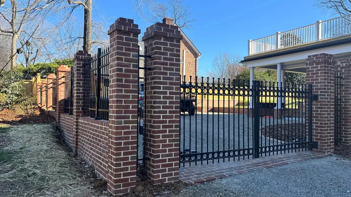 Black iron driveway gate ring detail brick columns