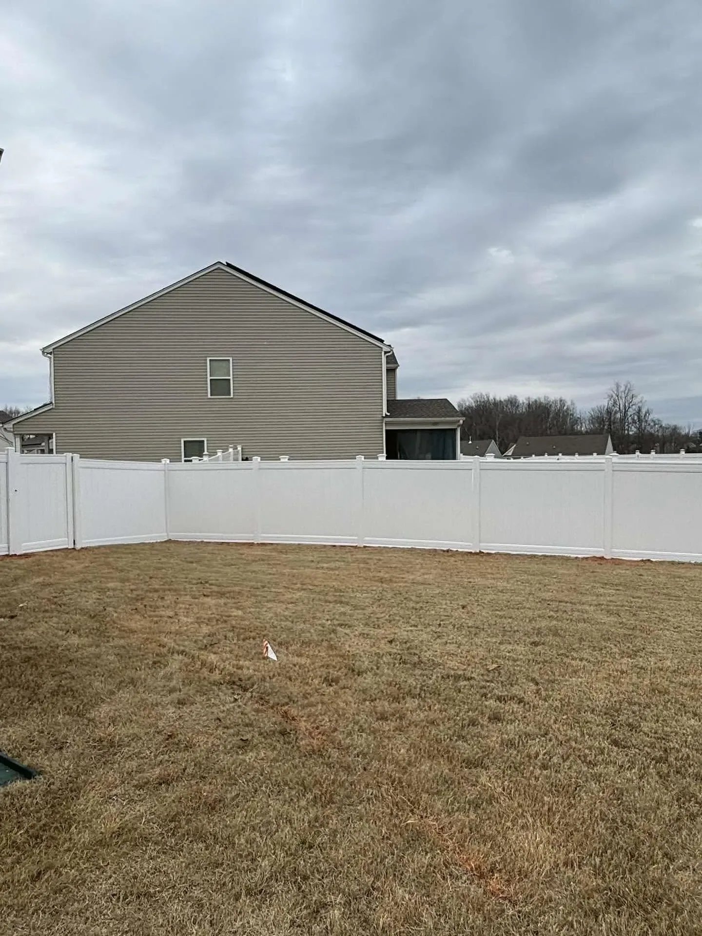 White vinyl privacy fence backyard tan two story neighbor house